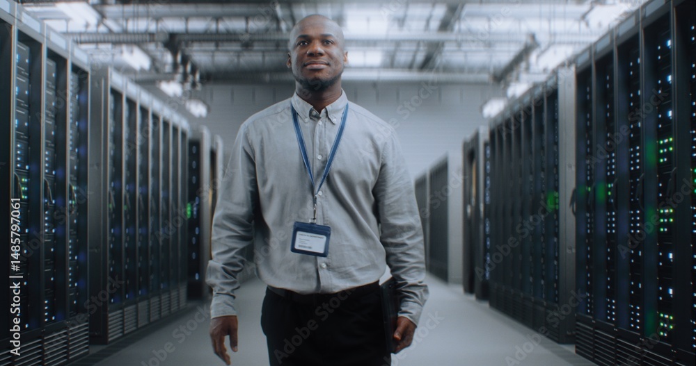 Fototapeta premium Big Data Center with Server Racks: Professional African American Specialist with Tablet Computer Walking In Warehouse. Internet Servers, Information Technology, Cyber Security and Telecommunications.