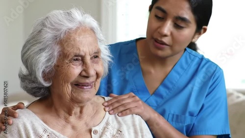 Compassionate Caregiver Places Hands on Elderly Woman's Shoulders in an Indoor Setting Displaying Warmth Affection and Support in Nursing Home