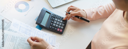 Deduction planning, debt asian young woman  hand using calculator to calculating money balance from bill and income, cost budget expenses for pay money form personal individual on table at home.
