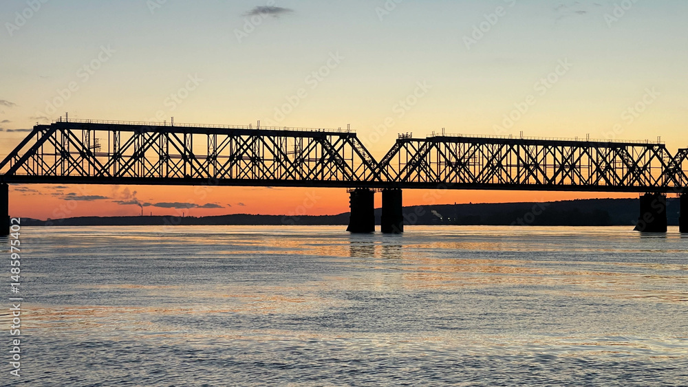 Fototapeta premium Railway bridge over the river at sunset