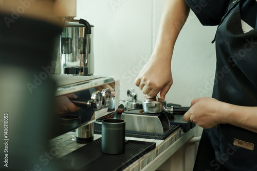 Foto Closeup male barista tamping coffee grounds at espresso machine inside cafe, art