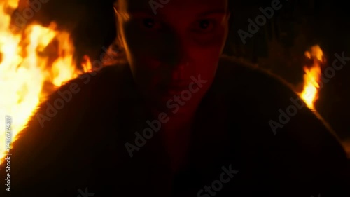 Intense firelit portrait capturing mysterious movement and dramatic atmosphere