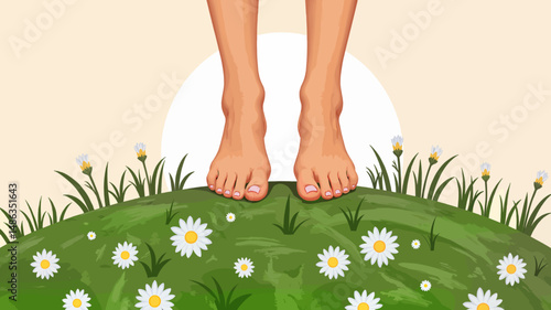 Bare feet standing on grassy hill covered with daisies at sunrise  