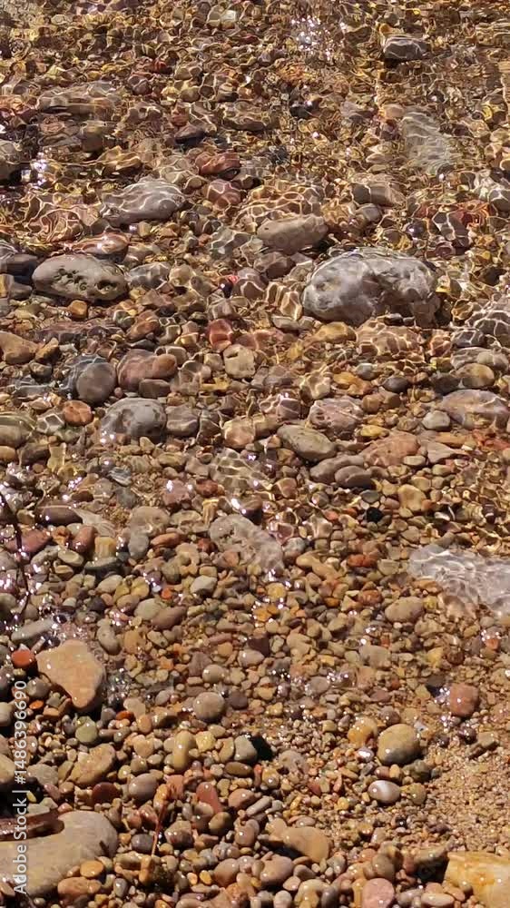 Waves breaking in the shoreline on a pebbles beach Waves breaking in the shoreline on a pebbles beach