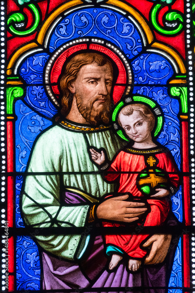 Obraz premium Stained glass (19th century) of Saint Joseph holding baby Jesus Christ in his arms.