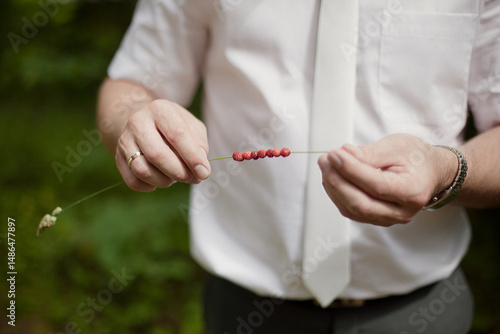 groom holding wild strawberries 