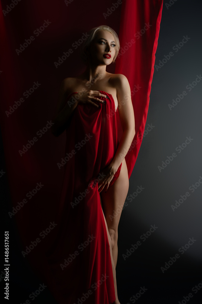 Elegant woman posing with red cloth in a studio setting Elegant woman posing with red cloth in a studio setting