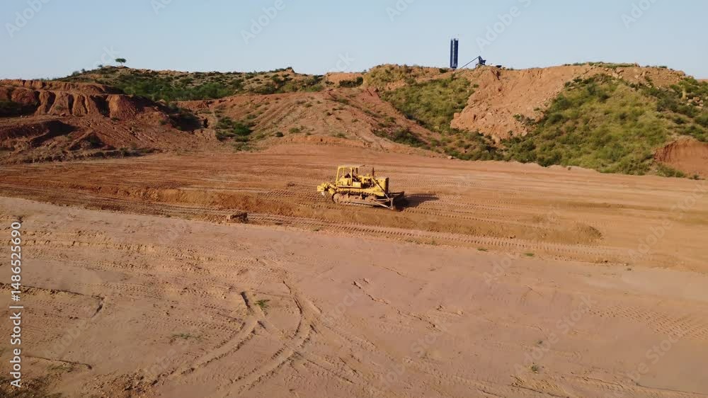 Heavy Machine Leveling Ground in Rural Area with Crusher Plant on Mountain in Background Daylight Footage Heavy Machine Leveling Ground in Rural Area with Crusher Plant on Mountain in Background Daylight Footage