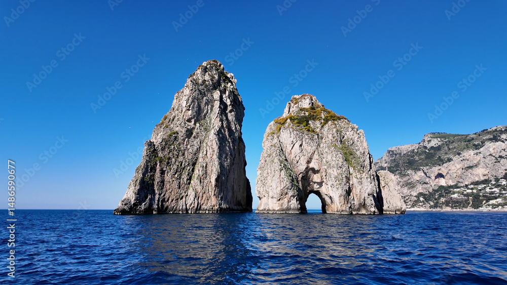 Fototapeta premium Faraglioni At Capri In Naples Italy. Island Landscape. Tourism Landmark. Faraglioni At Capri In Naples Italy. Bay Of Naples Skyline. Cultural Heritage Coastal. Paradise Capri Island.