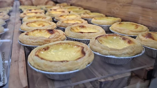 Freshly Baked Egg Tarts on Display in a Bakery Showcase.