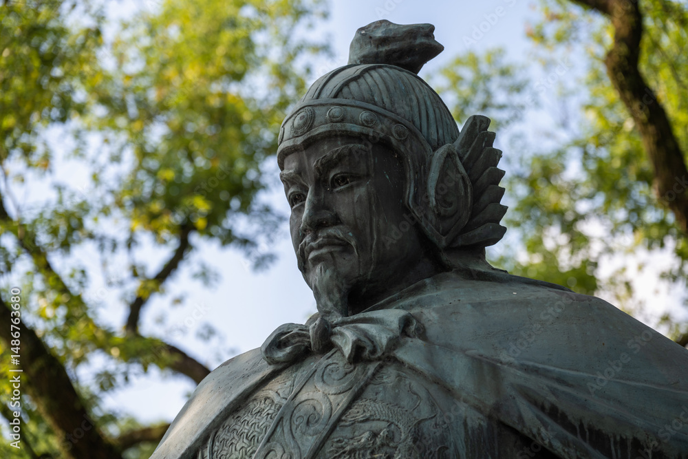Fototapeta premium Bronze Statue of a Historical Figure in a Park