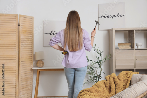 Young woman with hammer and...