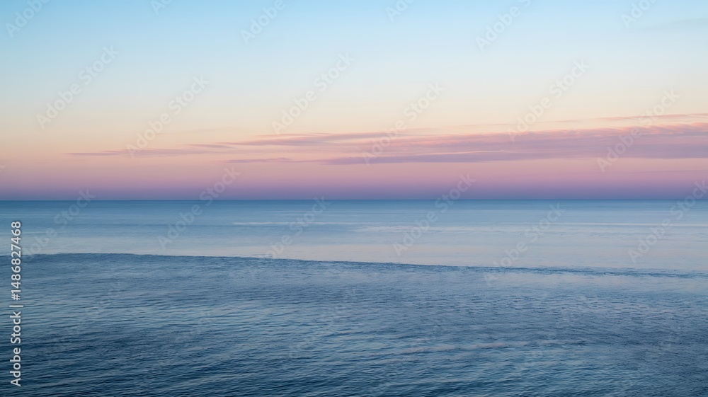 Fototapeta premium Calm ocean under a beautiful pastel sky at twilight or dawn