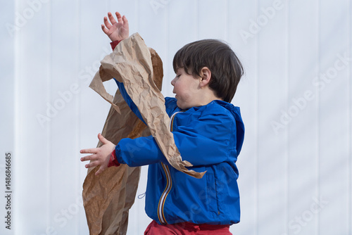 young boy playing with paper