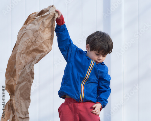 young boy playing with paper