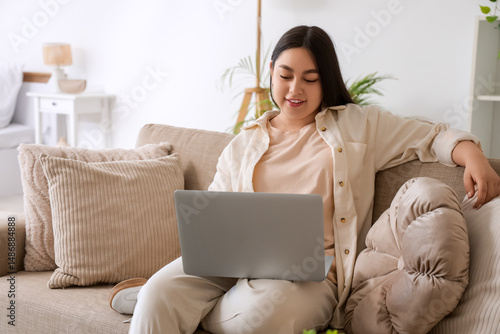 Smiling young woman using l...