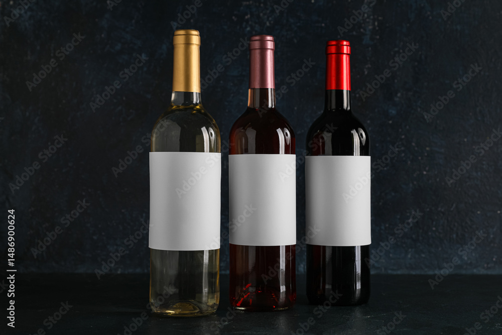 Fototapeta premium Bottles of wine with blank labels on black background