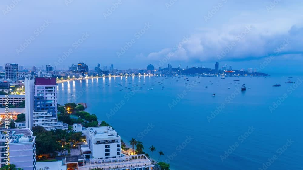 Time lapse of Pattaya city with beach, many boats in the sea and many buildings in the morning sunrise. It is a landmark and a popular destination.