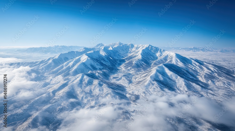 Aerial View of Snow Covered Mountain Range Under a Bright Blue Sky Aerial View of Snow Covered Mountain Range Under a Bright Blue Sky