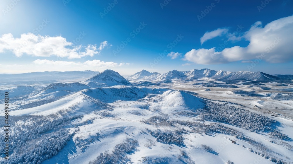 Obraz premium Aerial View of Snow Covered Mountain Range Under Blue Sky