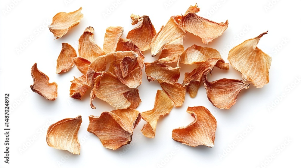A scattering of dried, pale orange flower petals against a stark white background A scattering of dried, pale orange flower petals against a stark white background