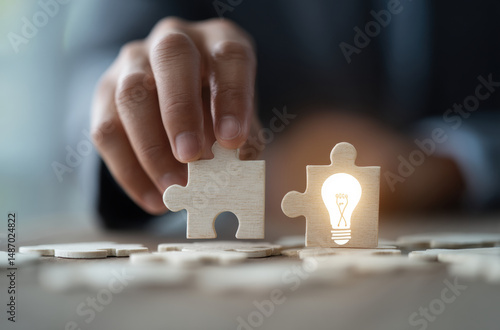 Hand placing puzzle piece with glowing light bulb symbolizing ideas and solutions, representing creativity and innovation