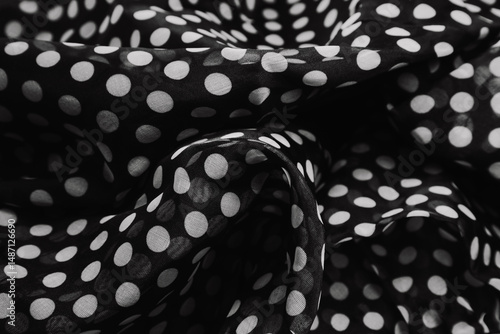 Black and white polka dots printed design fabric waves with ripples and folds.