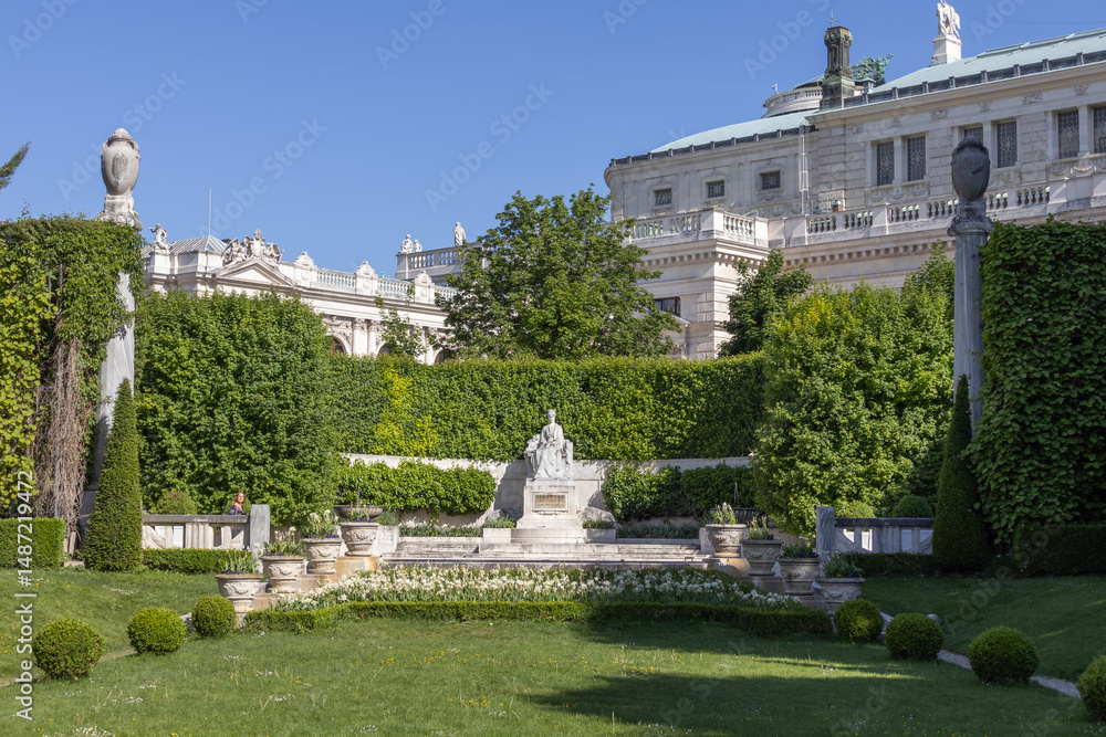 Obraz premium Monument to Empress Elisabeth (Sisi) Framed by Garden Architecture and Classical Building in Vienna