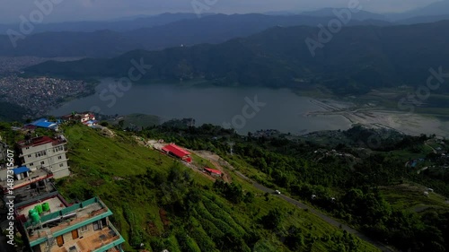 Aerial Forward Beautiful Shot Of Houses On Mountains By Rippled Lake - Pokhara, Nepal