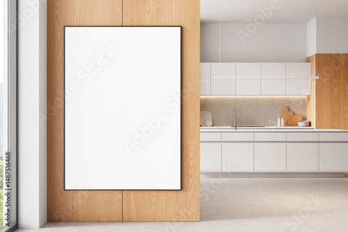 Blank framed poster on wooden wall in modern kitchen interior with clean white cabinets and minimalist layout for design mockup or template display. 3D Rendering