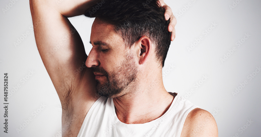 Obraz premium Studio, grooming and smelling of underarm, man and sniffing of odor in morning, cosmetics and deodorant. Clean, scent and person with routine for hygiene, white background and treatment for armpit