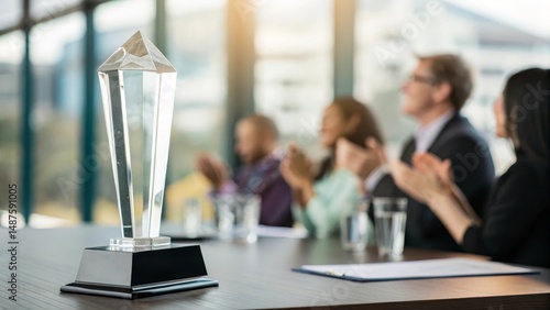 A crystal trophy sits on a conference table as a group of people applauds in a modern office setting.