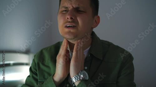 symptoms of a sore throat during a cold and virus.
Inflammation of the tonsils and sore throat.
A man with a sore throat cannot speak due to severe pain.
Sore throat