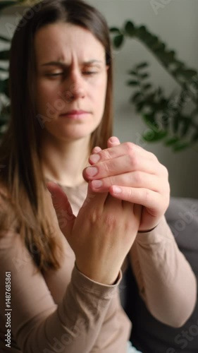 Vertical footage of sad female massage hand with wrist pain, rheumatoid arthritis. Young woman suffer from numbing pain in hand, numbness fingertip, arthritis inflammation, peripheral neuropathies