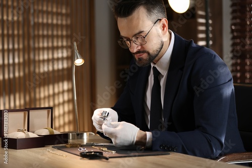 Obraz na płótnie Appraiser with loupe evaluating ring at table indoors