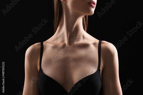Woman in bra on black background, closeup
