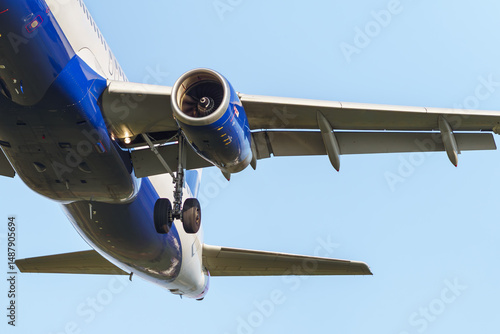 Close-up of an approaching passenger airplane preparing to land. Detailed view of the engine.