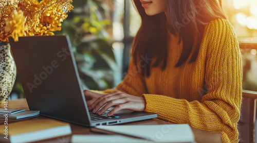 Close-up view of a woman working on a laptop.