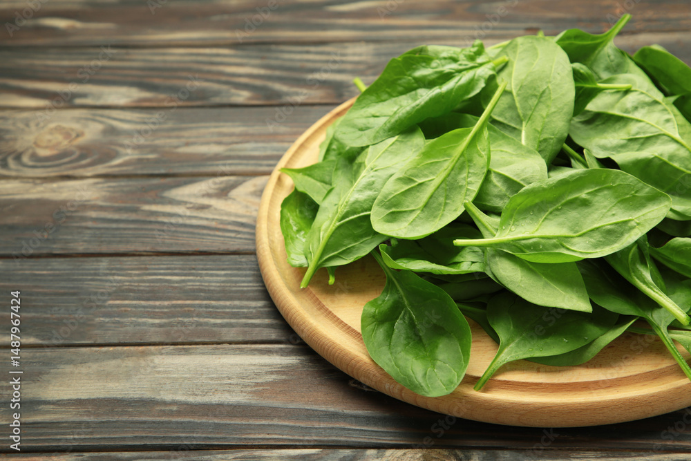 Fresh spinach leaves on cutting board on brown wooden background Fresh spinach leaves on cutting board on brown wooden background