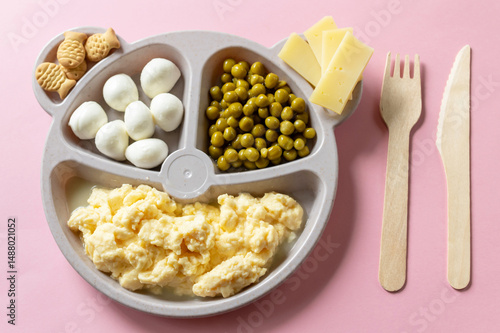 Baby food on a plate. Wooden fork and knife. Breakfast option for a child.