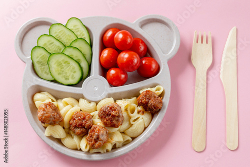 Baby food on a plate. Wooden fork and knife. Lunch or dinner option for a child.
