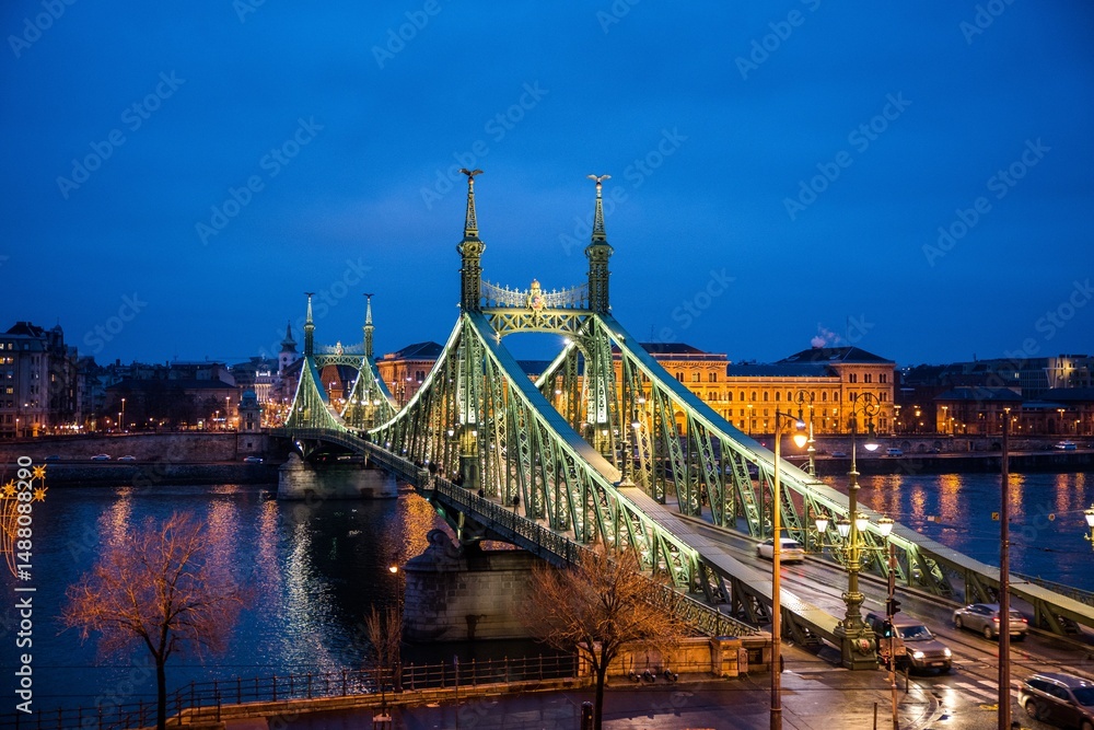 Obraz premium Budapest, Hungary - January 22 2023: Liberty Bridge (Szabadság híd) illuminated at dusk, spanning the Danube River in central Budapest.