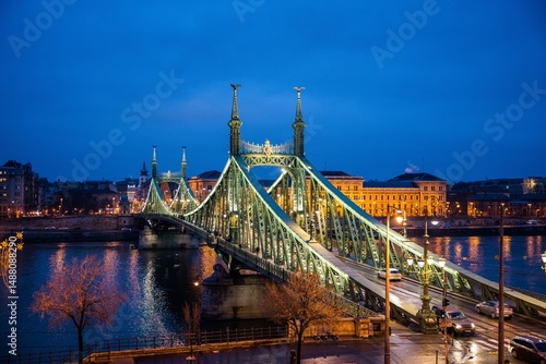 Budapest, Hungary - January 22 2023: Liberty Bridge (Szabadság híd) illuminated at dusk, spanning the Danube River in central Budapest.