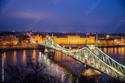 Budapest, Hungary - January 22 2023: Liberty Bridge (Szabadság híd) illuminated at dusk, spanning the Danube River in central Budapest.