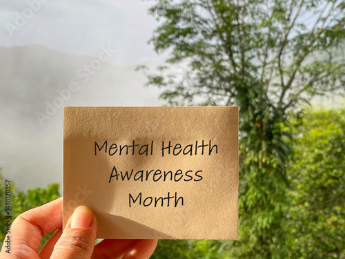 Mental Health Awareness Concept - mental health awareness month text on paper with nature background. Stock photo