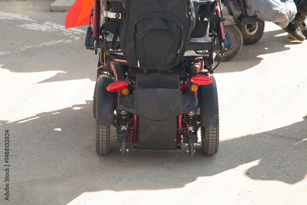 Fototapeta premium An electric wheelchair user drives around the city.