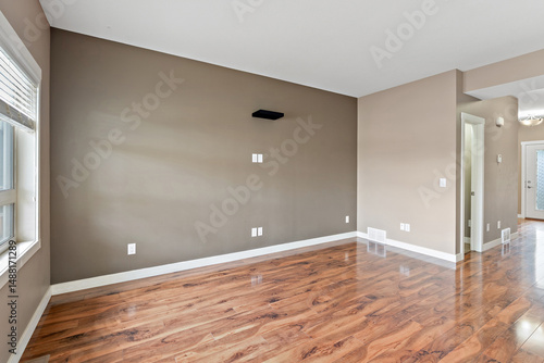 Fotografie Large, empty room with a tan wall and wooden floors