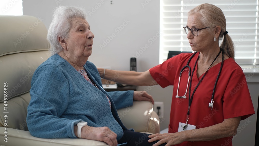 Obraz premium A compassionate caregiver provides support to an elderly woman in a healthcare facility, ensuring engagement and comfort during their interaction at home.