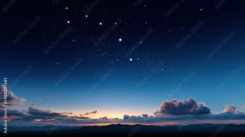 Fototapeta premium Majestic Ursa Major constellation gleams brightly in the serene deep blue twilight sky above the dark silhouette of mountains and soft clouds at the horizon.