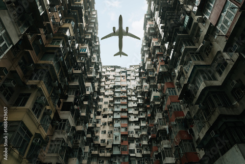 Canvas Print Airplane over Yick Fat Building in Hong Kong highlighting urban density and trav